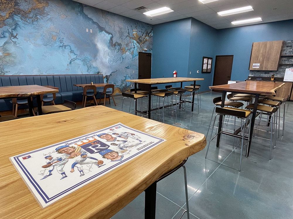 Basys eating area with live edge wood tables and Royals team memorabilia 