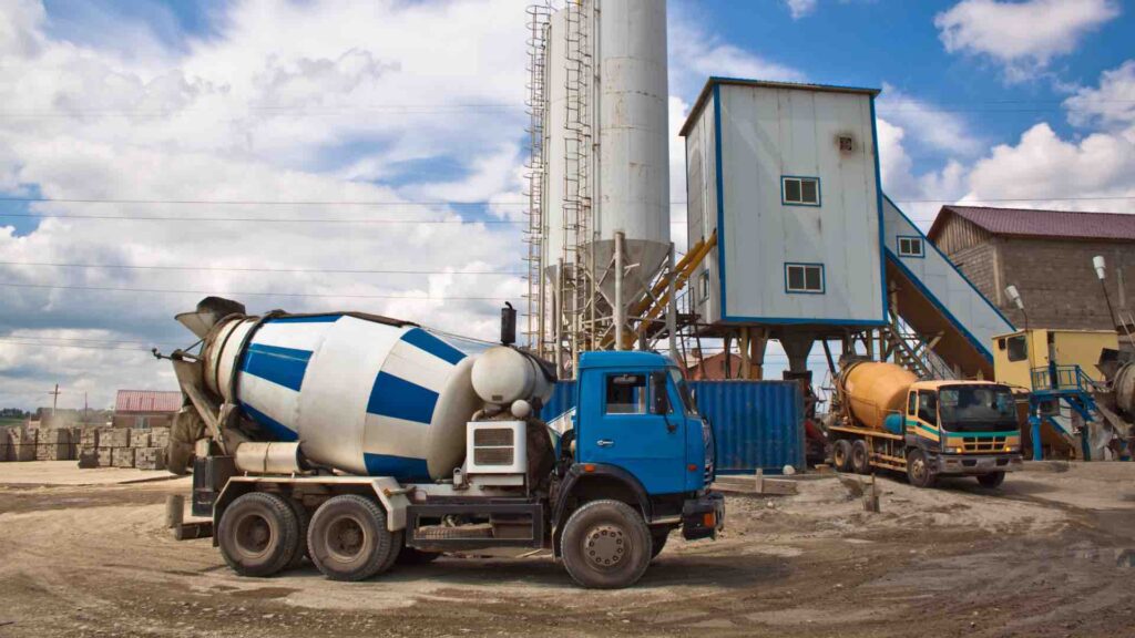 A concrete mixing truck driving on a work site
